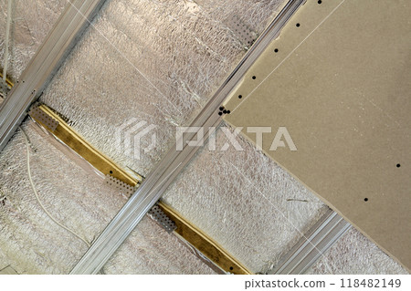 Room under construction with silver aluminum insulation foil and drywall on walls and ceiling. 118482149