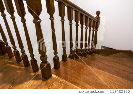 Close-up detail of brown wooden oak stairs in new renovated house. Staircase between two floors Close-up detail of brown wooden oak stairs in new renovated house. Staircase between two floors 118482150
