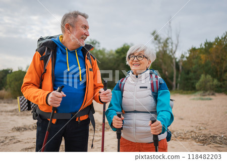 Hiking tourism adventure. Senior couple man woman enjoying outdoor recreation hiking on beach. Happy old people backpackers hikers enjoy walking hike trekking tourism active vacation beauty of nature 118482203