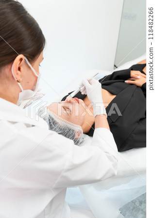 The young female client of cosmetic salon having a cleansing facial mask The young female client of cosmetic salon having a cleansing facial mask 118482266