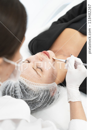 The young female client of cosmetic salon having a cleansing facial mask The young female client of cosmetic salon having a cleansing facial mask 118482267