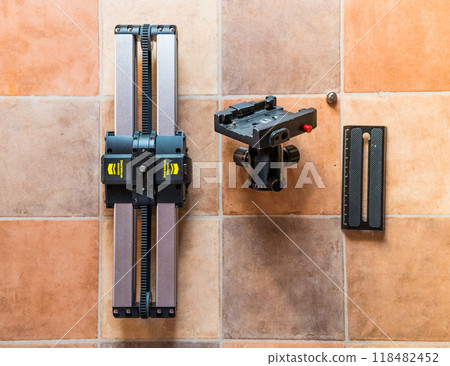Professional macro photography equipment lying on a tiled surface 118482452