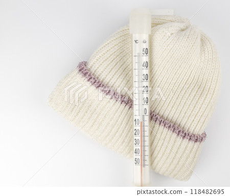 A thermometer showing the sub-zero temperature outside in celsius on a child's winter hat. The concept of a cold in winter. 118482695
