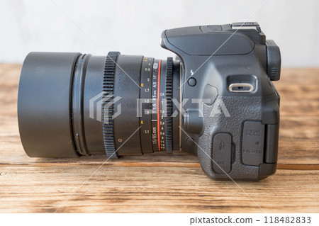 Professional digital camera lying on wooden table Professional digital camera lying on wooden table 118482833