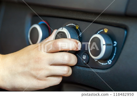 Closeup of a human hand rotating car temperature control, shallow depth of field shot 118482950