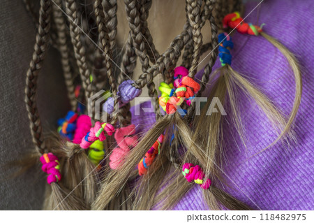 Close up of braid hair of little girl with colorful rubber bands 118482975