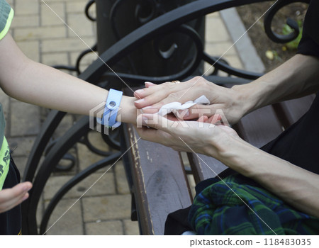 female hands wipe a childs hand with a wet napkin 118483035