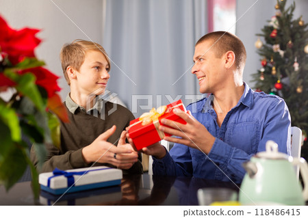 Man giving Christmas present to his son 118486415