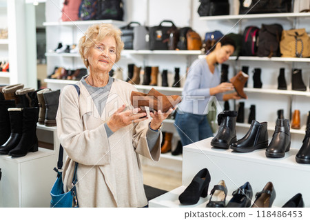 Mature woman demonstrates stylish loafers with heels 118486453