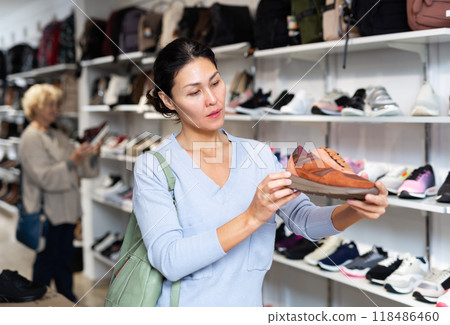 woman selecting running shoes in shoeshop woman selecting running shoes in shoeshop 118486460
