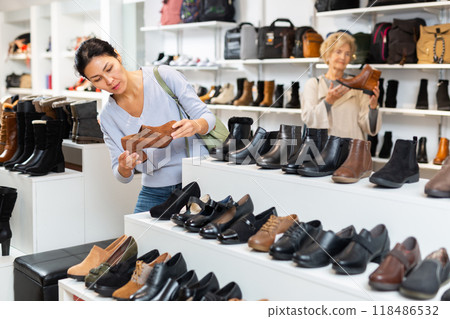 Focused Asian woman chooses stylish loafers with heels Focused Asian woman chooses stylish loafers with heels 118486532