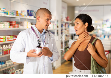 Male doctor offering treatment to woman with sore throat Male doctor offering treatment to woman with sore throat 118486554