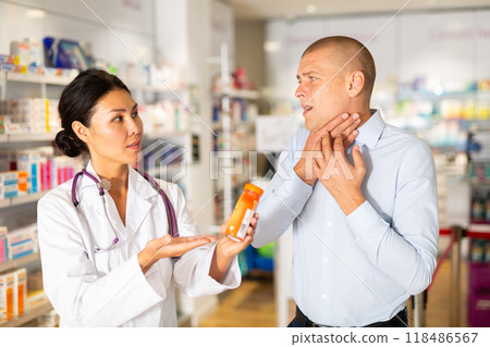 Man complaining to female druggist about sore throat 118486567