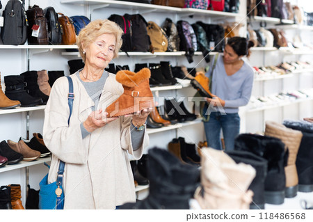 Mature european woman chooses winter boots Mature european woman chooses winter boots 118486568