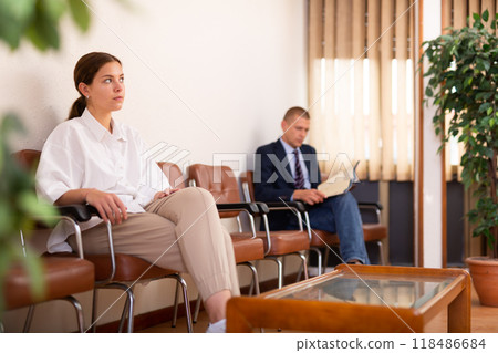 Focused young girl is sitting in the lobby, waiting for her turn Focused young girl is sitting in the lobby, waiting for her turn 118486684
