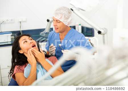 Woman complains of toothache to dentist Woman complains of toothache to dentist 118486692