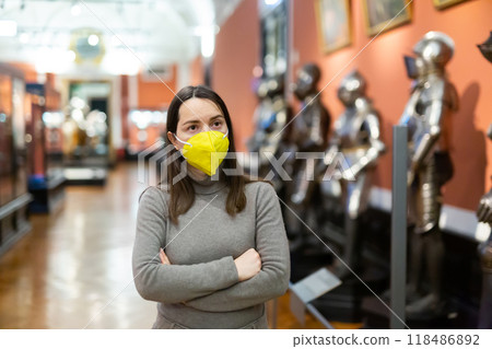 Interested brunette in mask visiting exhibition of historical museum 118486892