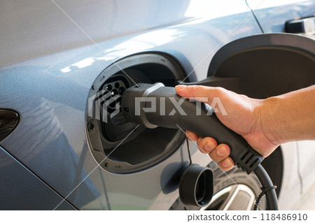 Man about to charge his electric car. Man about to charge his electric car. 118486910