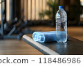 Water bottle and towel placed on a gym bench symbolizing the essential elements of and for a fitness workout or exercise routine 118486986