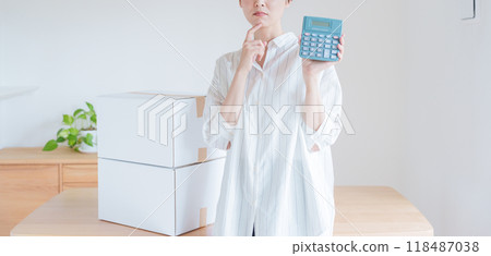 A woman estimating moving costs on a calculator 118487038