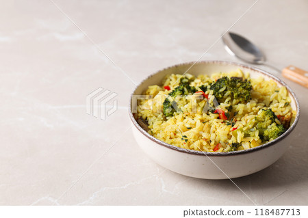 Pilaf in bowl and spoon on light background, space for text Pilaf in bowl and spoon on light background, space for text 118487713
