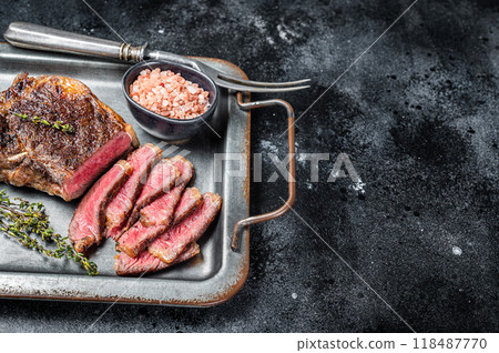 Grilled Wagyu Striploin beef meat steak or new york steak in a steel tray. Black background. Top view. Copy space Grilled Wagyu Striploin beef meat steak or new york steak in a steel tray. Black background. Top view. Copy space 118487770