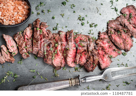 BBQ Roast sliced Skirt beef meat steak in steel tray with thyme. Black background. Top view BBQ Roast sliced Skirt beef meat steak in steel tray with thyme. Black background. Top view 118487781