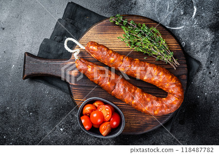 Traditional spanish Chorizo sausage, dry cured pork meat. Black background. Top view Traditional spanish Chorizo sausage, dry cured pork meat. Black background. Top view 118487782