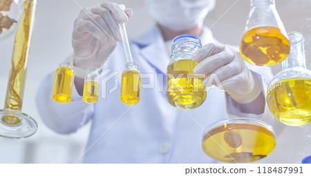 A focused scientist uses a pipette to transfer liquid from a small vial, surrounded by multiple glass flasks, highlighting precision in laboratory work. A focused scientist uses a pipette to transfer liquid from a small vial, surrounded by multiple glass flasks, highlighting precision in laboratory work. 118487991