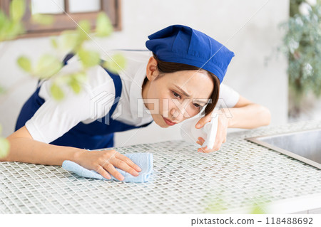 A woman from a housekeeping service cleaning the kitchen A woman from a housekeeping service cleaning the kitchen 118488692