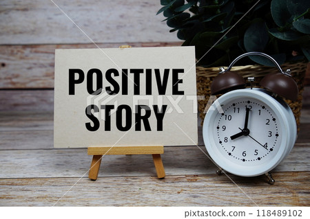 Positive Story text motivational and inspiration quote with alarm clock on wooden background 118489102