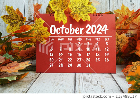October 2024 monthly calendar with maple leaf decoration on wooden background for planning and management 118489117