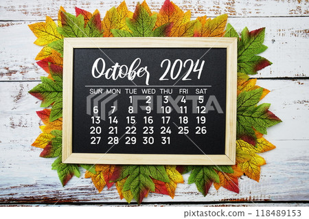 October 2024 monthly calendar with maple leaf on wooden background 118489153