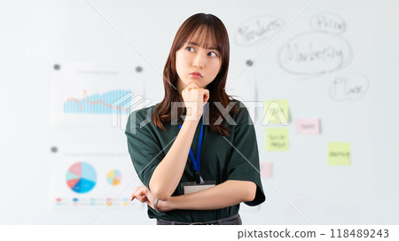 A young businesswoman thinking in front of a whiteboard 118489243