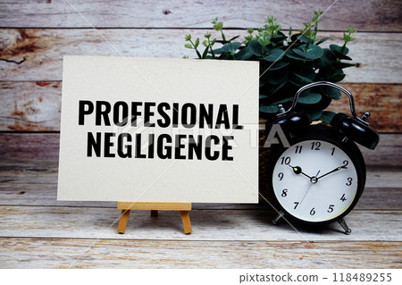 Professional Negligence text on paper card and easel standing with alarm clock on wooden background 118489255