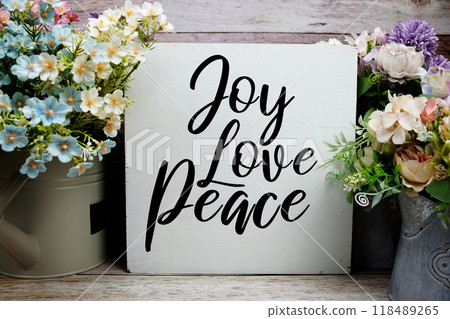 Joy Love Peace quotes text with flowers decoration on wooden background, motivational inspirational concept Joy Love Peace quotes text with flowers decoration on wooden background, motivational inspirational concept 118489265