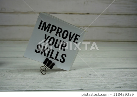 Improve Your Skills text message write on sticky note on wooden background 118489359
