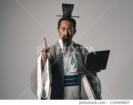 A scene where a great figure from Chinese history, such as one from the Romance of the Three Kingdoms, is giving a presentation using a laptop 118489667