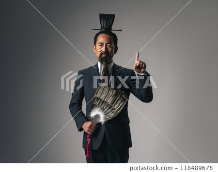 中國歷史上的武將,如《三國演義》中的諸葛亮,穿著西裝進行解釋的場景。 中國歷史上的武將,如《三國演義》中的諸葛亮,穿著西裝進行解釋的場景。 118489678