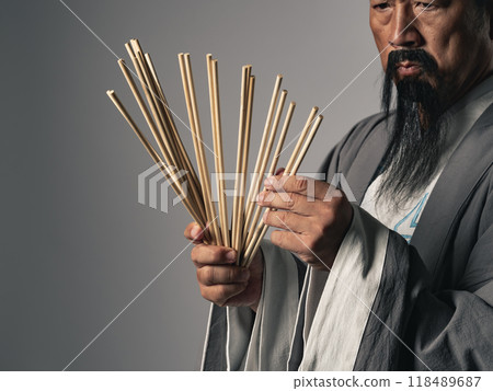 身穿漢服的男子用竹籤算命。 身穿漢服的男子用竹籤算命。 118489687