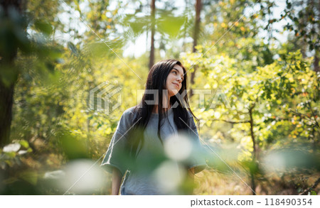 A young girl who breathes fresh air and relieves stress in the forest. A young girl who breathes fresh air and relieves stress in the forest. 118490354
