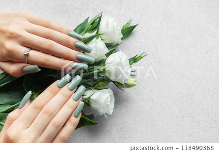 Elegant hands with green nail polish holding a bouquet of white roses Elegant hands with green nail polish holding a bouquet of white roses 118490368