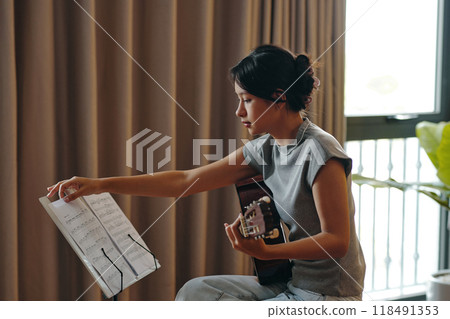 Concentrating on Guitar Practice by Reading Sheet Music Concentrating on Guitar Practice by Reading Sheet Music 118491353