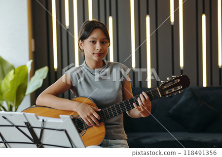 Playing Acoustic Guitar in Modern Music Studio Setting Playing Acoustic Guitar in Modern Music Studio Setting 118491356