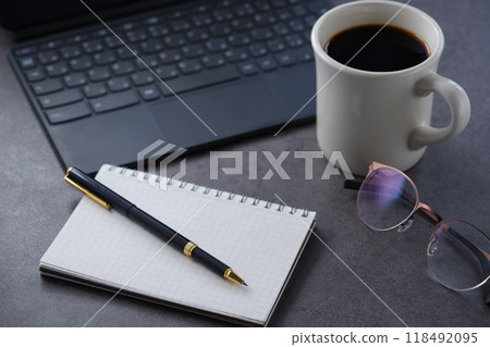 Image of spreading a laptop and notebook on a desk and doing desk work while drinking coffee Image of spreading a laptop and notebook on a desk and doing desk work while drinking coffee 118492095