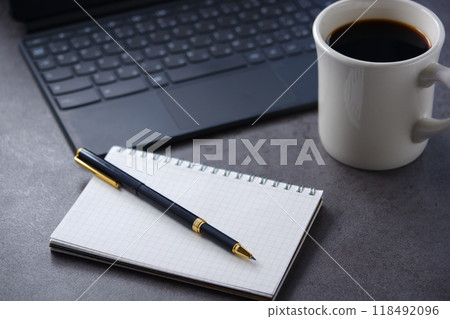 將膝上型電腦和筆記本放在桌子上,一邊喝咖啡一邊做案頭工作的圖片 將膝上型電腦和筆記本放在桌子上,一邊喝咖啡一邊做案頭工作的圖片 118492096