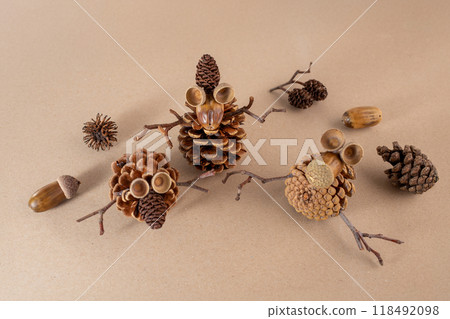 three crafted figures made from natural materials such as pine cones, acorns, and twigs, showcasing a form of art and craft that repurposes elements found in nature., 118492098