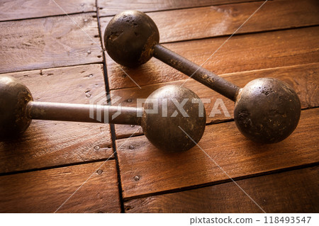 Old rusty dumbbells on wood background texture 118493547