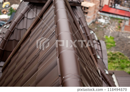 Close-Up of Modern Brown Metal Roof with Urban Background 118494870