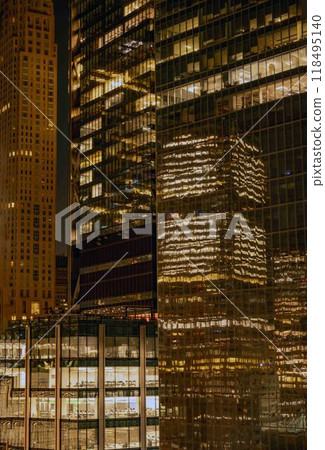 Nighttime city bulding architecture closeup glowing windows reflection 118495140
